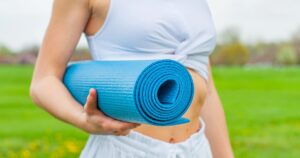 femme avec un tapis de yoga sous le bras